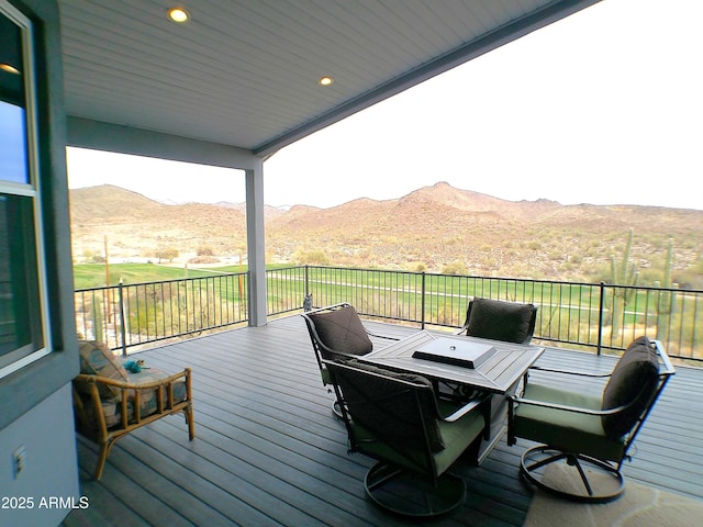 deck with outdoor dining space and a mountain view