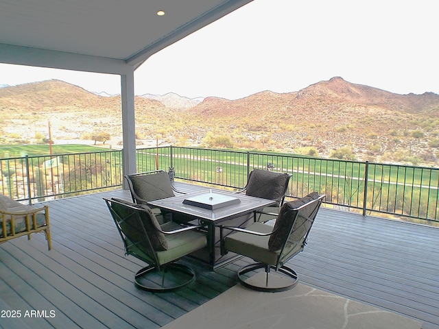 wooden deck featuring outdoor dining space and a mountain view