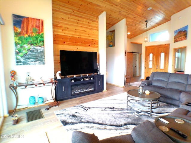 living room featuring high vaulted ceiling, a barn door, visible vents, wood ceiling, and light wood-type flooring