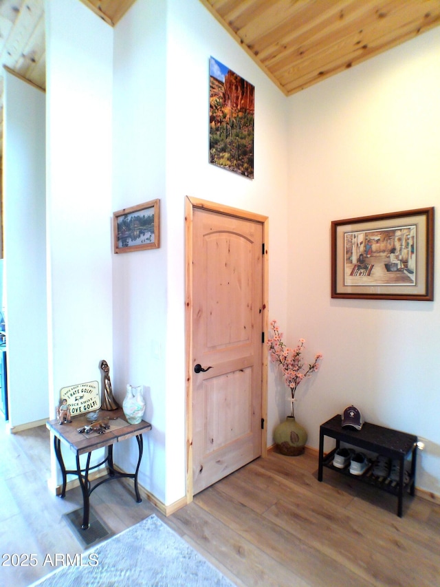 foyer with wood ceiling, baseboards, and wood finished floors