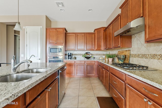 kitchen with light stone countertops, decorative backsplash, stainless steel appliances, and exhaust hood