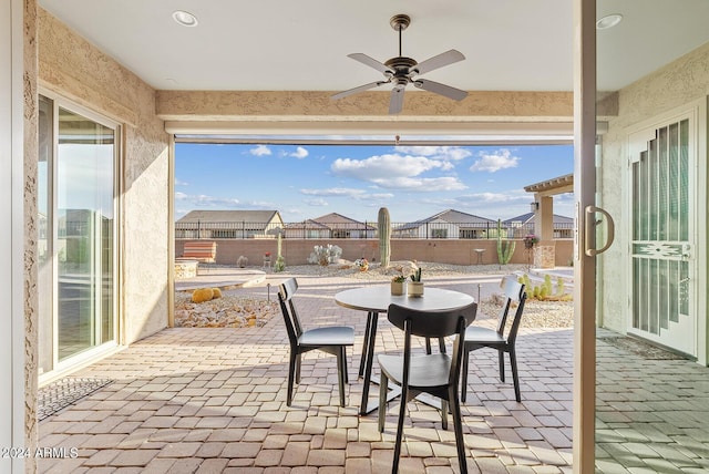 sunroom / solarium featuring ceiling fan and plenty of natural light