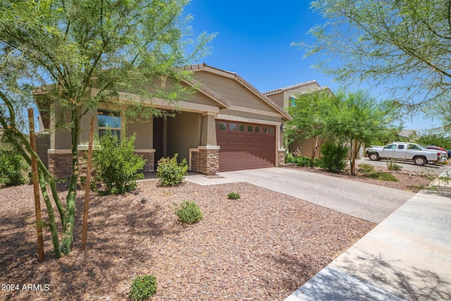 view of front of house featuring stone siding, driveway, a garage, and stucco siding
