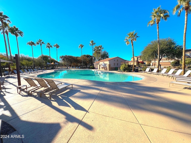 community pool with a patio and fence
