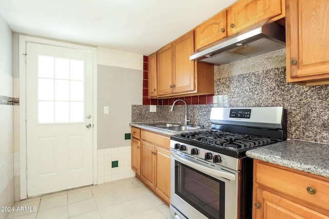 6219 S 12th Pl, Phoenix, AZ 85042 - kitchen with stainless steel range with gas cooktop, under cabinet range hood, light tile patterned floors, and tasteful backsplash