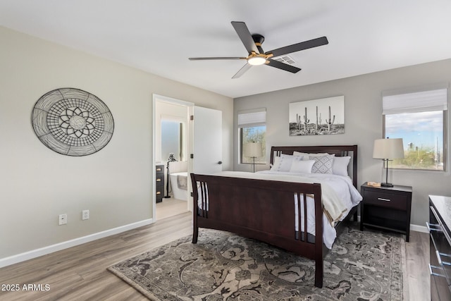 bedroom with multiple windows, wood finished floors, and baseboards