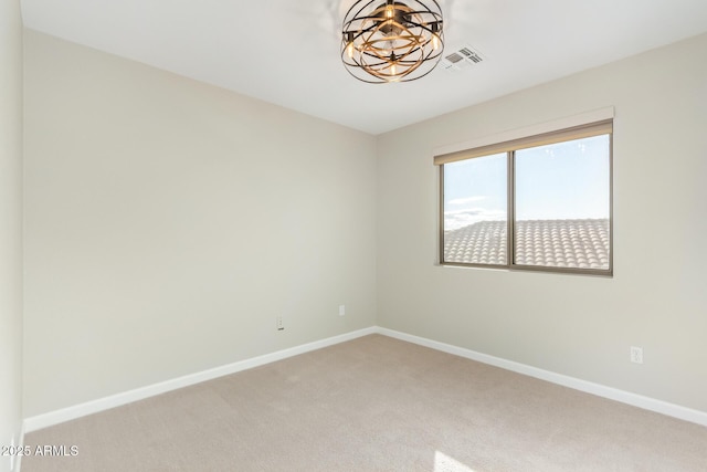 empty room featuring light carpet, a notable chandelier, visible vents, and baseboards