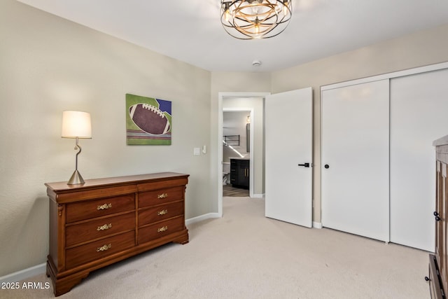 bedroom with a closet, light colored carpet, and baseboards