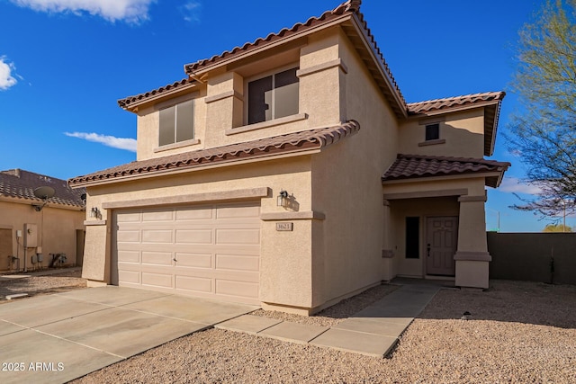 mediterranean / spanish-style home with an attached garage, concrete driveway, and stucco siding