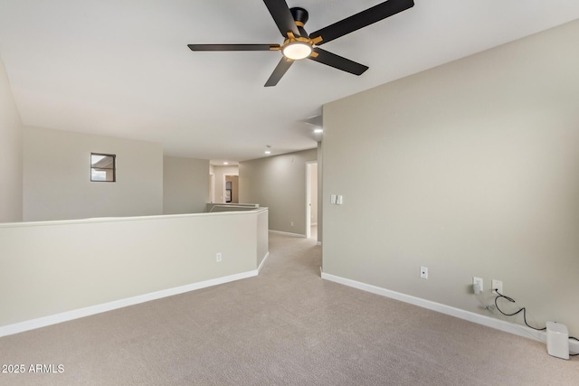 unfurnished room featuring light carpet, ceiling fan, and baseboards