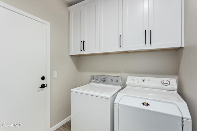 laundry area featuring independent washer and dryer, wood finished floors, cabinet space, and baseboards