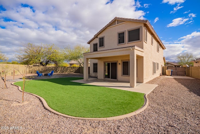 back of property with a tile roof, a fenced backyard, a patio, and stucco siding