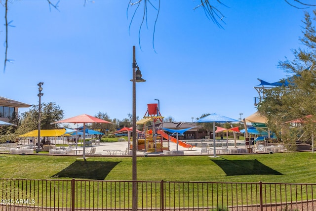 community jungle gym with a yard and fence