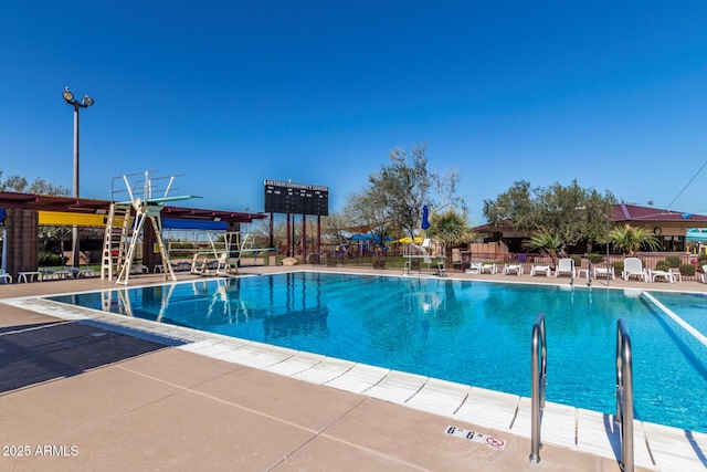 community pool with a patio area, fence, and mail area