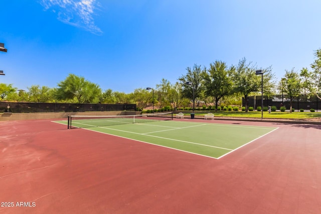 view of tennis court featuring fence