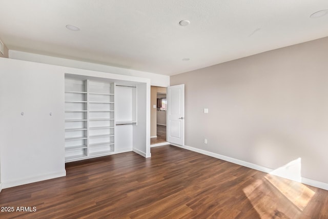 unfurnished bedroom featuring a closet and dark hardwood / wood-style floors