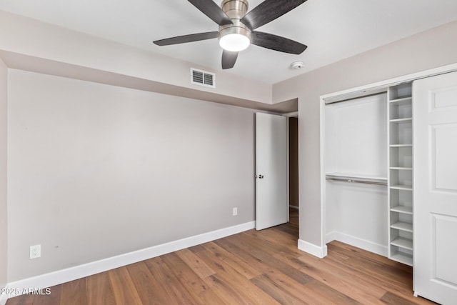 unfurnished bedroom featuring ceiling fan, light wood-type flooring, and a closet