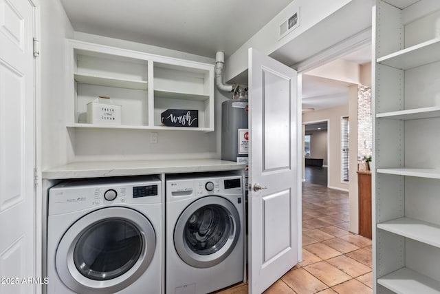 laundry room featuring light tile patterned flooring, washer and dryer, and gas water heater