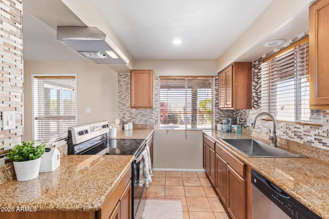 kitchen with sink, wall chimney range hood, stainless steel appliances, and tasteful backsplash