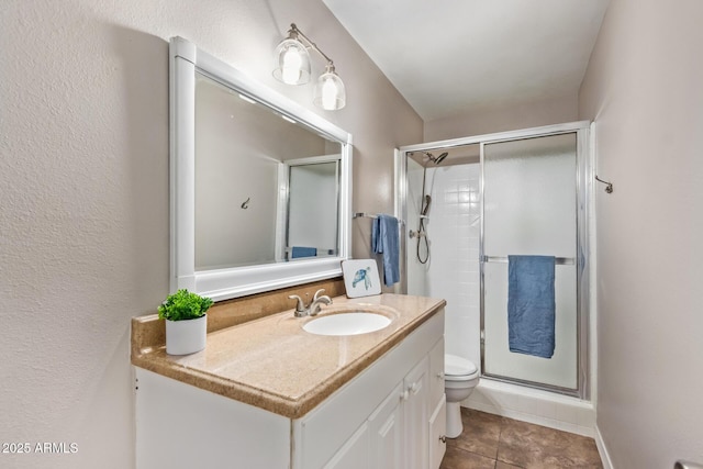 bathroom with tile patterned floors, vanity, toilet, and walk in shower