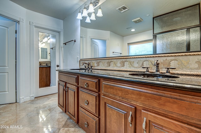 bathroom featuring backsplash, tile floors, and dual vanity