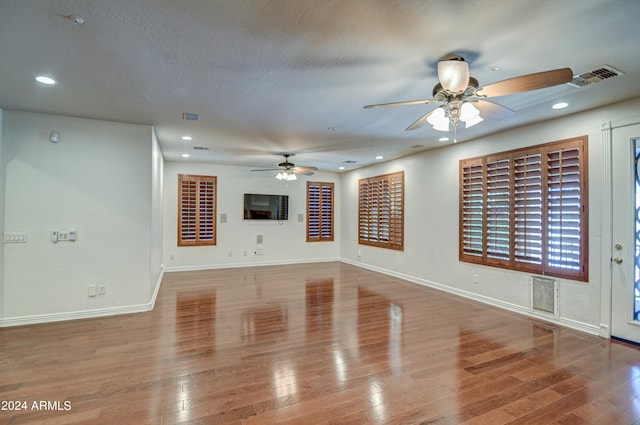 unfurnished living room with a textured ceiling, ceiling fan, and hardwood / wood-style floors