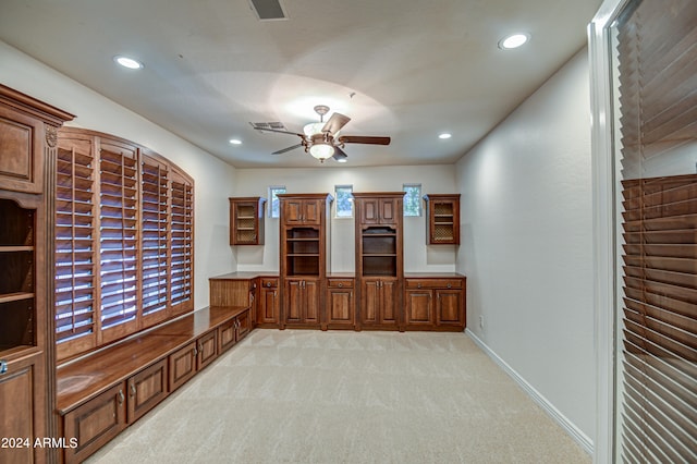 unfurnished office with ceiling fan and light carpet