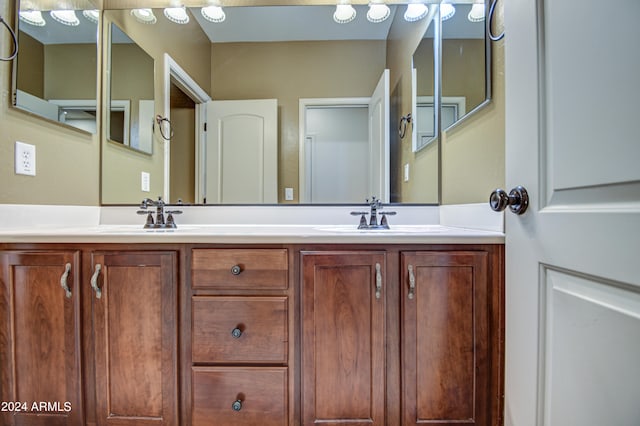 bathroom featuring dual sinks and vanity with extensive cabinet space