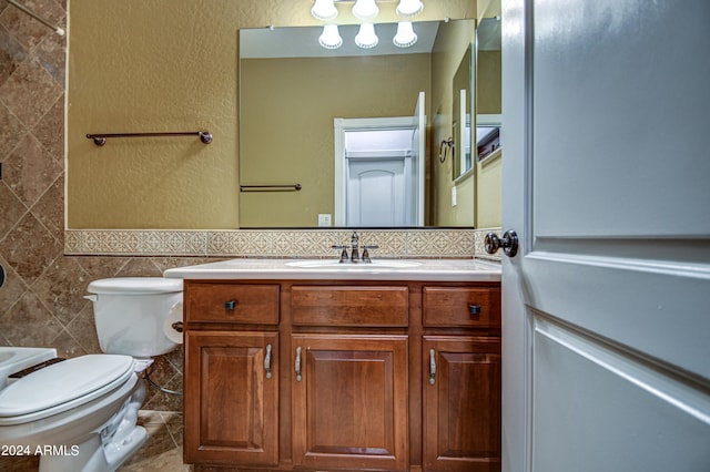 bathroom featuring tile walls, oversized vanity, toilet, tasteful backsplash, and tile floors