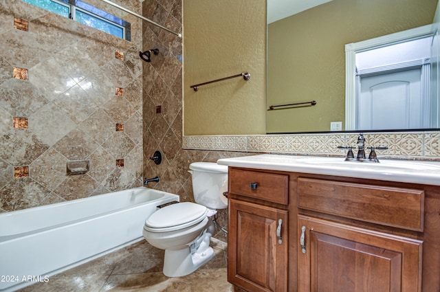 full bathroom with tile flooring, tiled shower / bath, tile walls, vanity with extensive cabinet space, and toilet