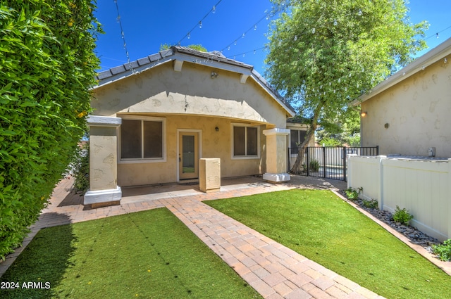 back of house featuring a lawn