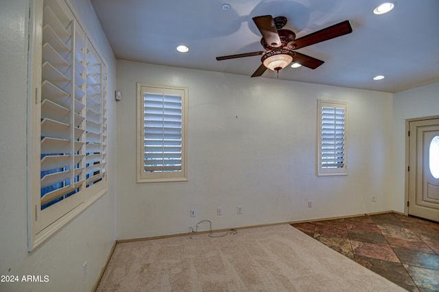 tiled empty room featuring ceiling fan