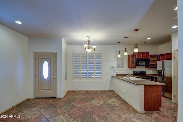 kitchen featuring dark tile floors, decorative light fixtures, a chandelier, black appliances, and kitchen peninsula