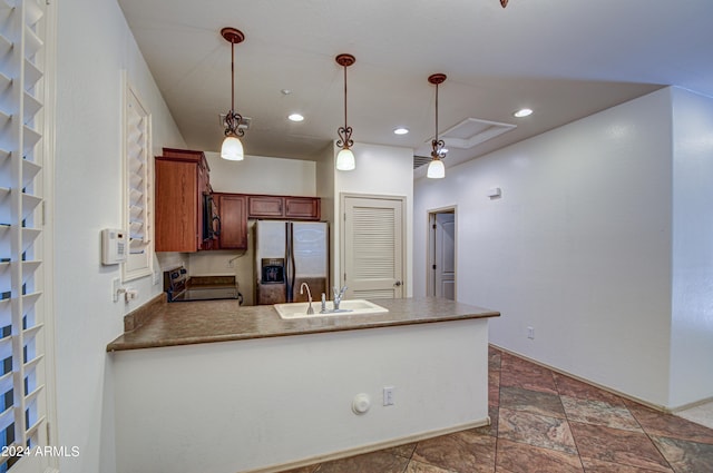 kitchen with dark tile floors, range, sink, pendant lighting, and stainless steel refrigerator with ice dispenser