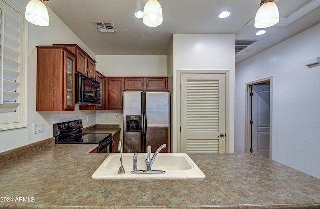 kitchen featuring sink, hanging light fixtures, and black appliances