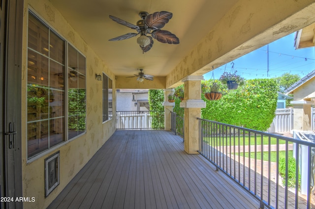 wooden deck featuring ceiling fan and a lawn