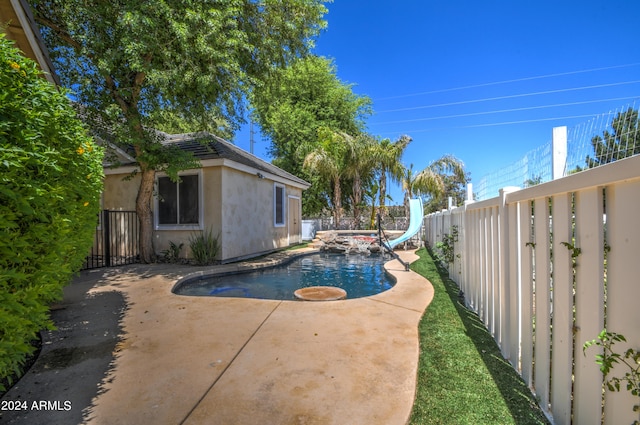 view of swimming pool with a patio and a water slide