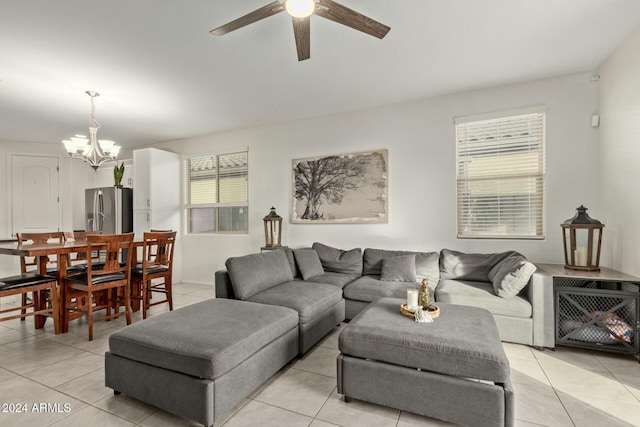 living room featuring ceiling fan with notable chandelier and light tile patterned flooring