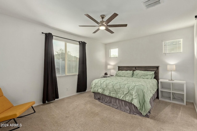 bedroom featuring multiple windows, ceiling fan, and light colored carpet