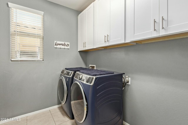 laundry room with light tile patterned flooring, cabinets, and separate washer and dryer