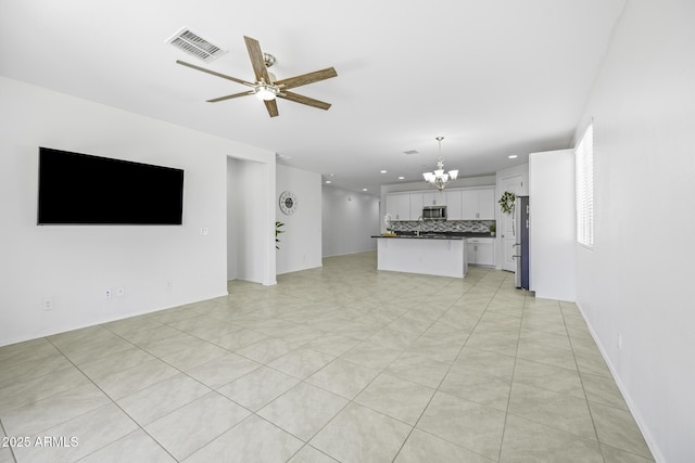 unfurnished living room with ceiling fan with notable chandelier, light tile patterned floors, visible vents, and recessed lighting