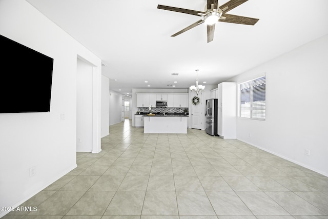 unfurnished living room featuring baseboards, light tile patterned floors, recessed lighting, and ceiling fan with notable chandelier