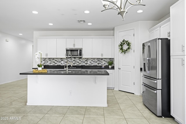 kitchen with an inviting chandelier, visible vents, dark countertops, stainless steel appliances, and tasteful backsplash