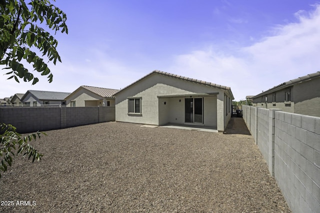 rear view of property featuring a fenced backyard, a patio, and stucco siding