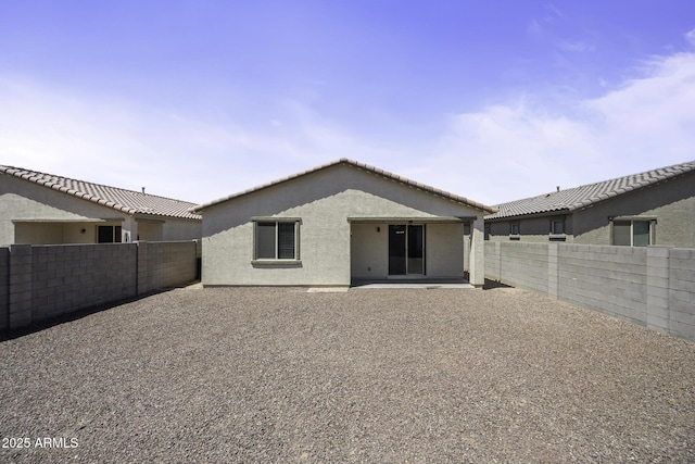 back of property featuring a fenced backyard, a patio, and stucco siding