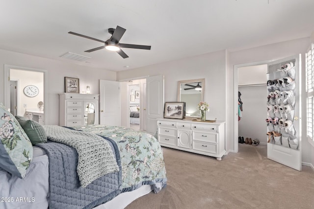 carpeted bedroom with a spacious closet, ceiling fan, and a closet