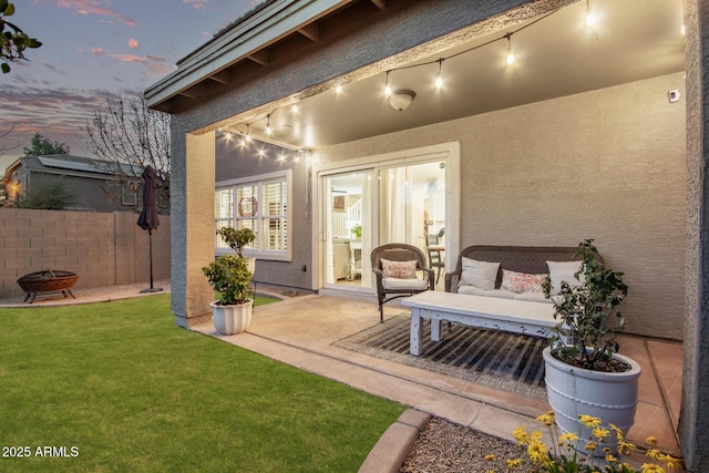 patio terrace at dusk with a yard and an outdoor fire pit