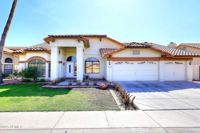 mediterranean / spanish house with a garage, concrete driveway, a tiled roof, a front lawn, and stucco siding