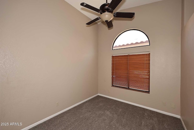 spare room with dark colored carpet, ceiling fan, lofted ceiling, and baseboards