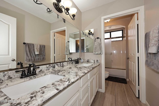 bathroom with wood finish floors, visible vents, a sink, and toilet